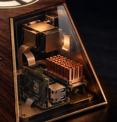 Close view of the clear glass face of BoardSeat, showing carefully arranged copper and brass electronics within a bronze frame.